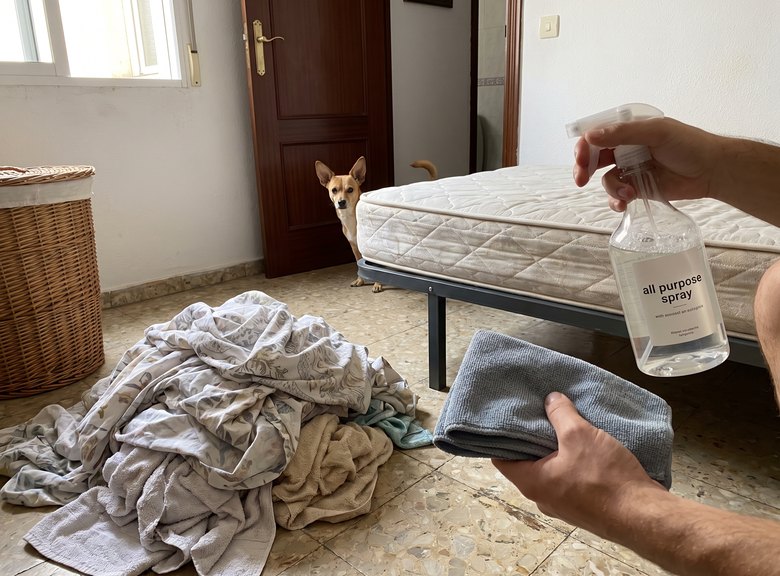 Sábanas cambiadas en el suelo del dormitorio y un perro asomando asustado por la puerta